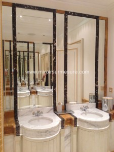 Miroir biseauté encastré dans une niche en marbre dans une salle de bain luxueuse